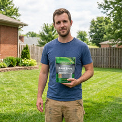 Man holding a package of Schultz Bare Spot grass seed in a backyard setting