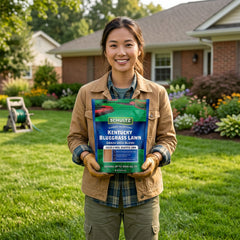 Woman holding a package of Schultz Kentucky Bluegrass Lawn Seed Blend in a garden setting.